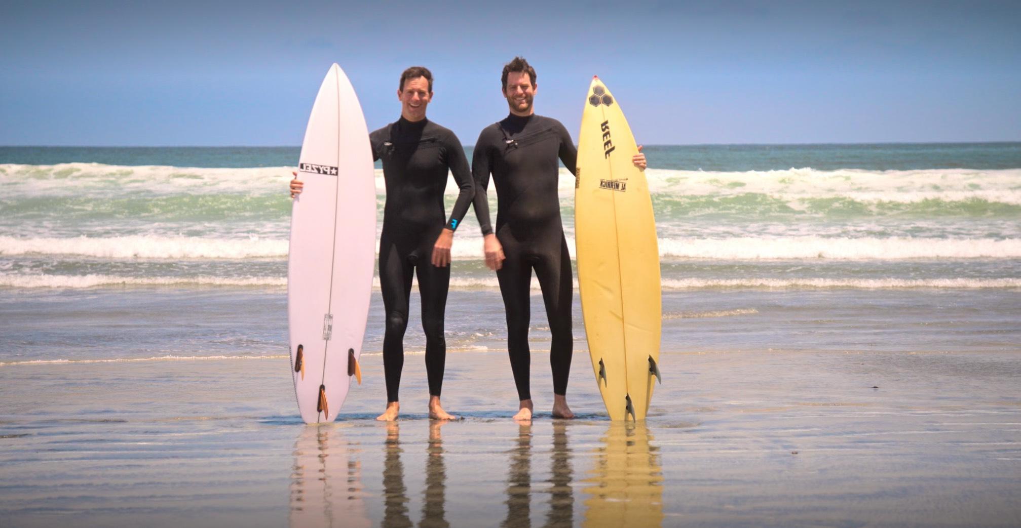 Twins Michael and Charlie, also known as the "Cheese Twins," pose together in wet suits on the beach with yellow and pink surfboards in the trailer for the new Netflix documentary series in which they star.