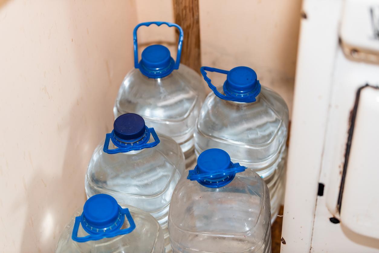 View of three large water jugs being stored in a home.