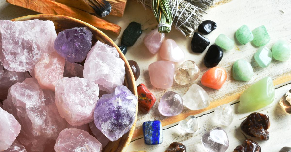 Photo of collection of various colorful crystals in a bowl and on a tabletop 