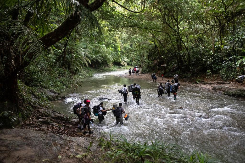 Haitian migrants crossing a river on the first day of their journey through the Darien Gap.