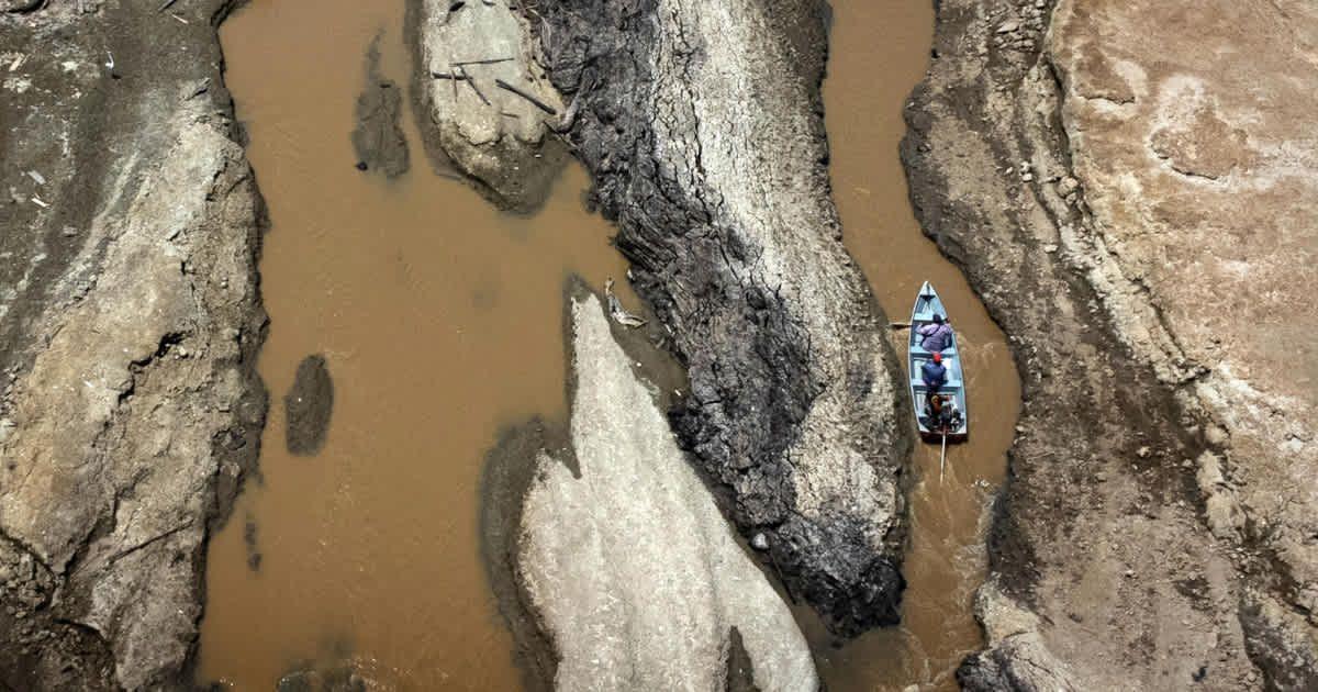 A small boat passes through a drought-hit region of the Amazon River (Cover Image Source: Getty Images | Bruno Zanardo)
