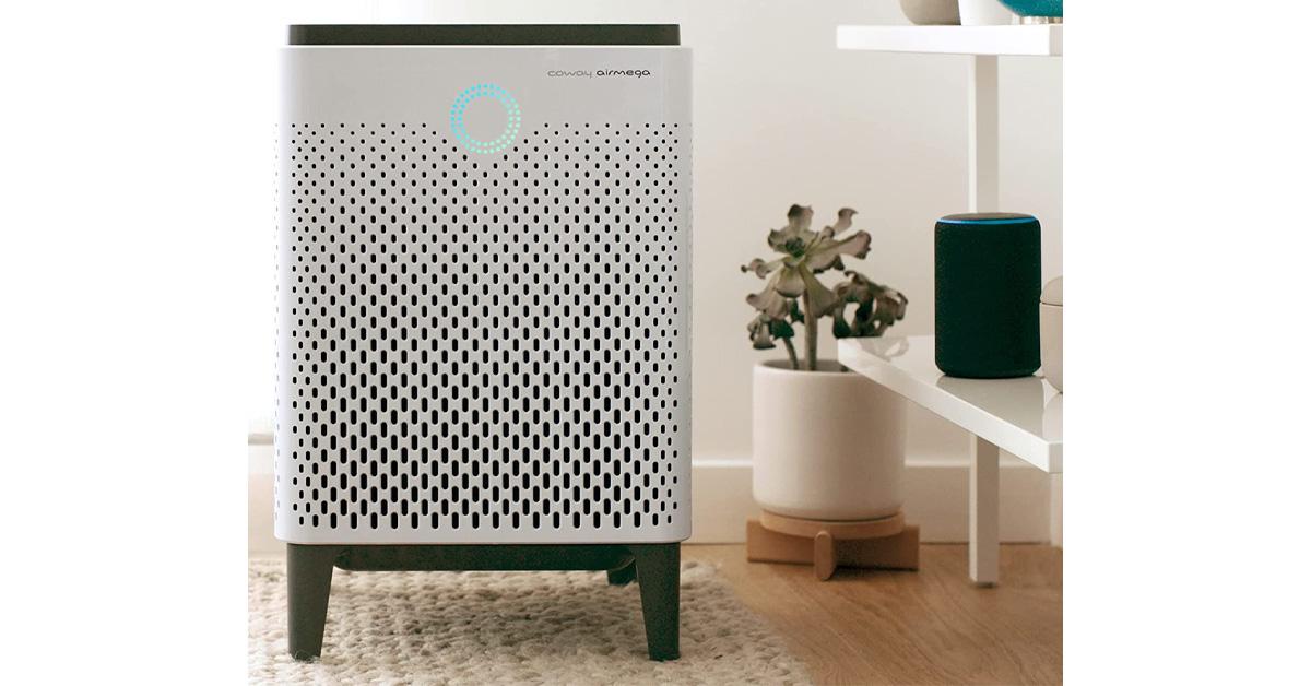 air purifier in a room with a rug, plant, bookshelf, and speaker