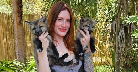 mikayla raines holding two baby foxes