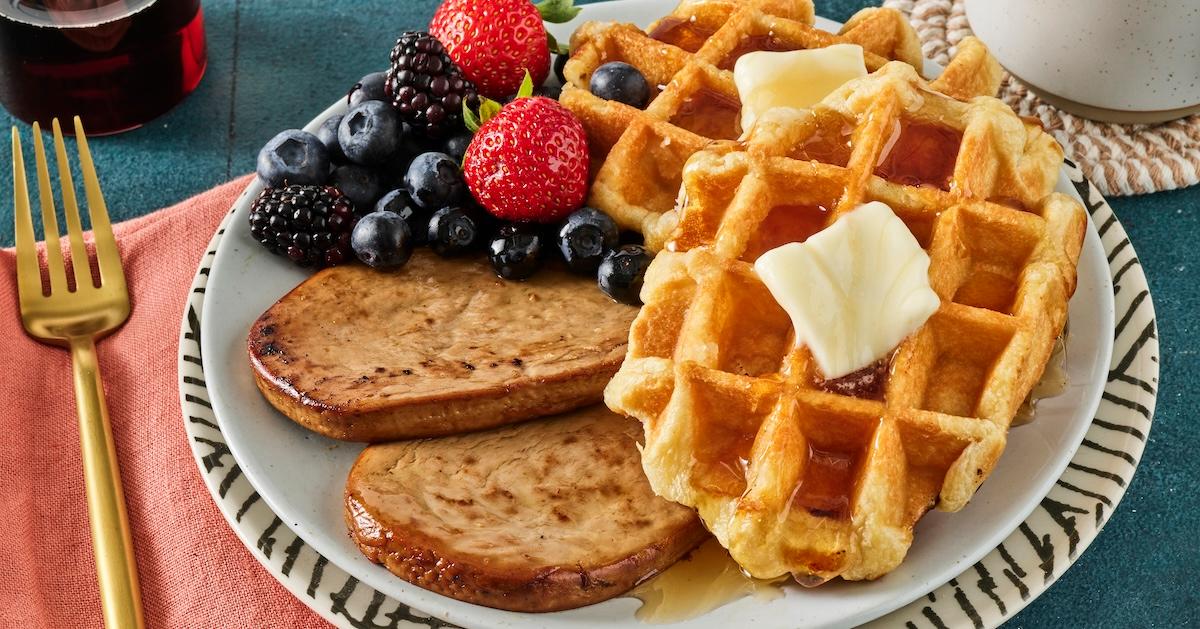 Vegan breakfast sausage, waffles, and berries on a plate