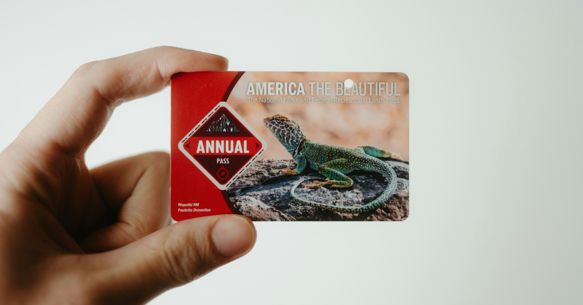 A person holds up a National Park Service pass