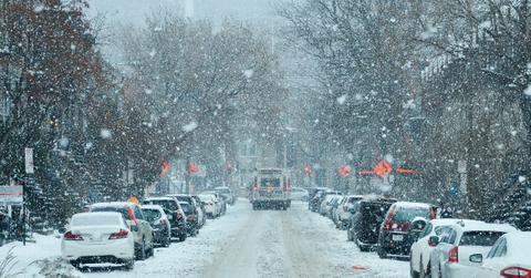 A city street is covered in a blanket of snow as winter weather kicks up