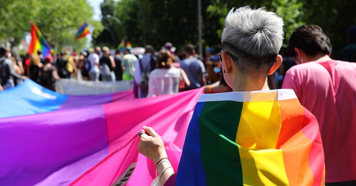 A person draped in a rainbow flag