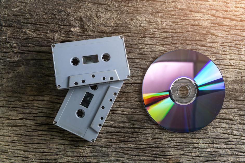 DVD sitting on wooden table next to two cassette tapes. 