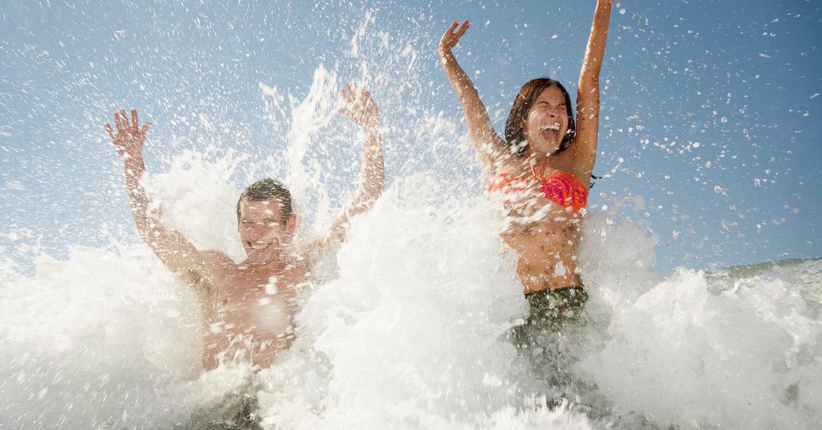 Man and woman laughing in ocean waves