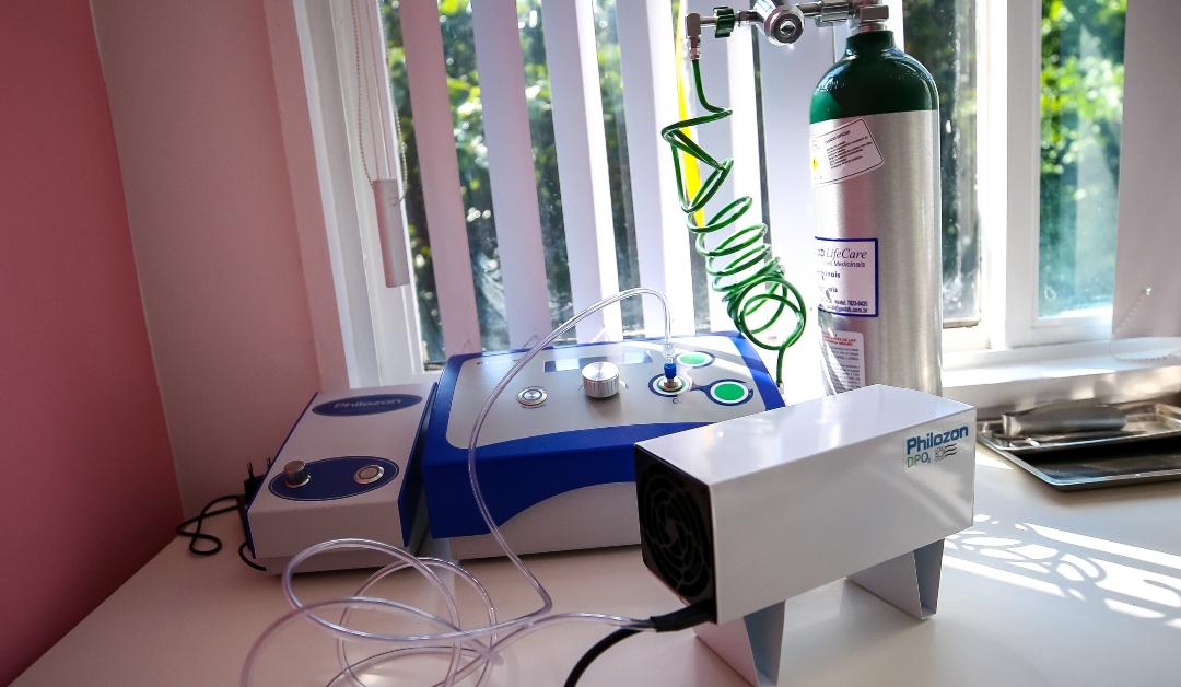 Three pieces of ozone therapy treatment equipment sitting on a white table in front of a window