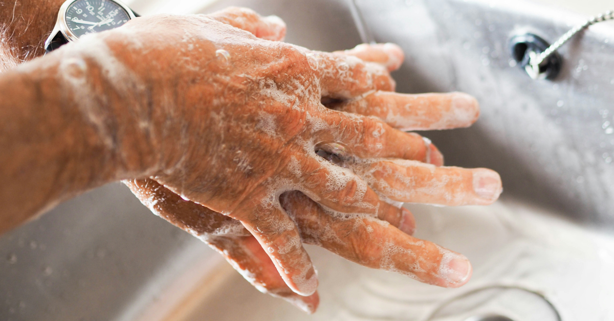 A person washes their hands with soap and water