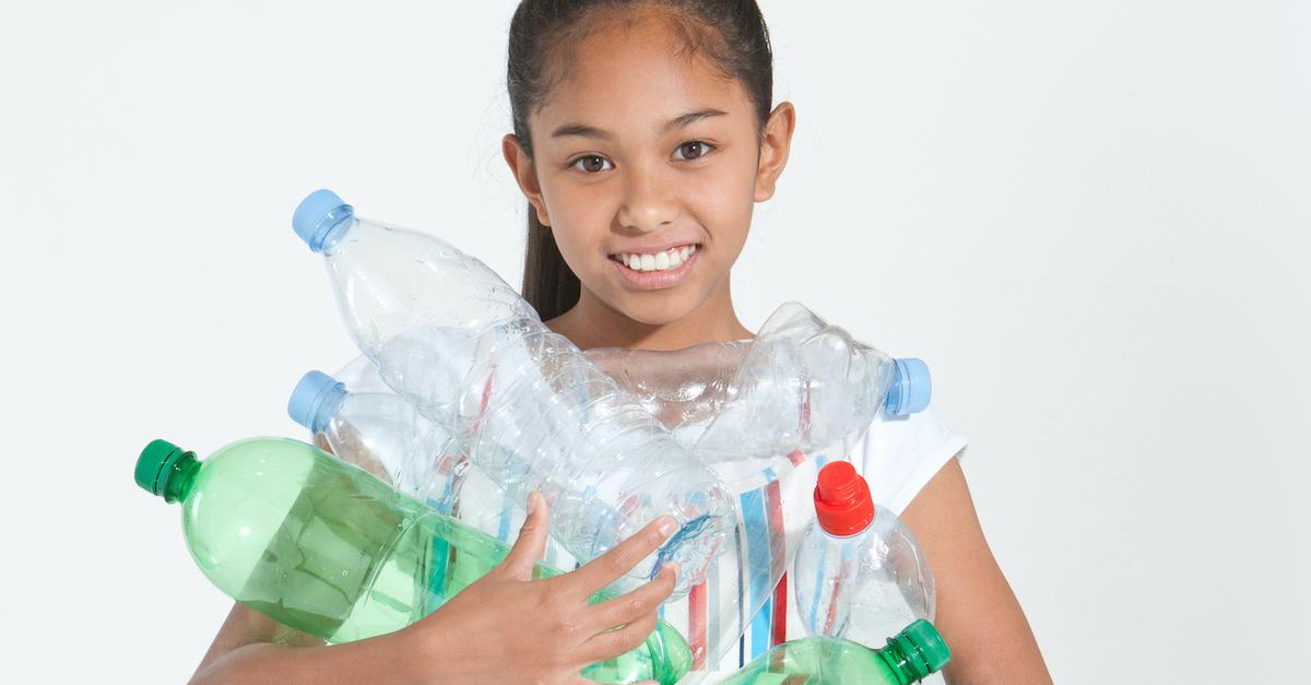 Young woman carrying plastic bottles. 