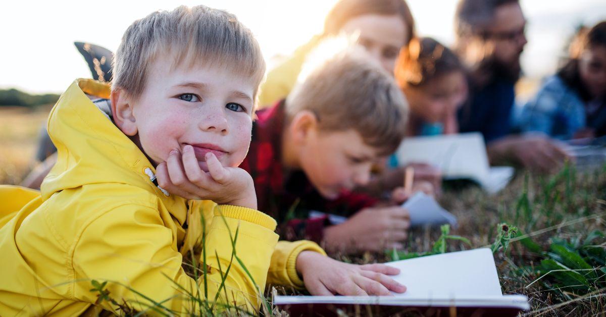 children writing and reading outside