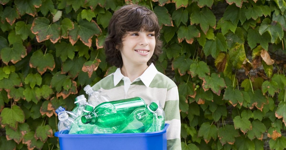 A young boy recycles.