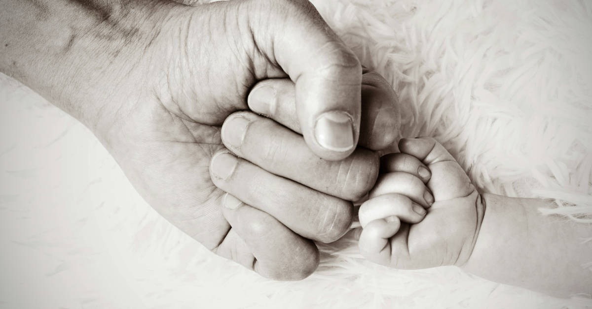 Closeup of a dad and baby fist bumping