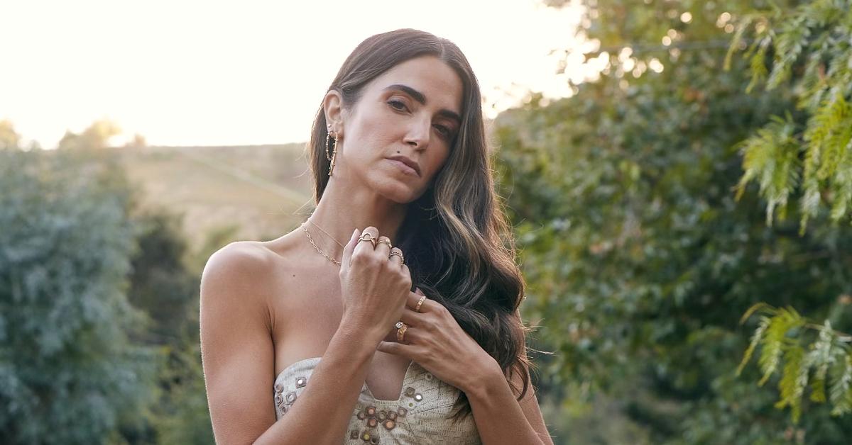 Photo of actor and eco-conscious entrepreneur Nikki Reed standing outside in front of vegetation