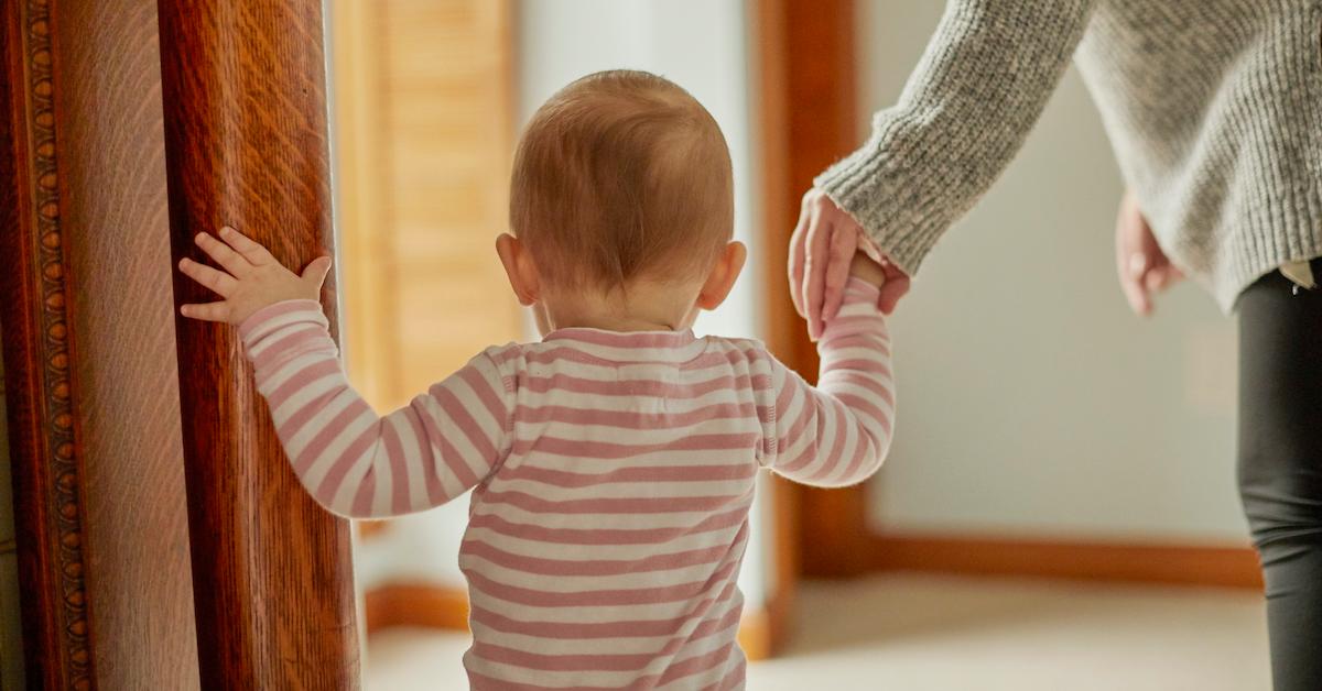 Small child holding a parent's hand.