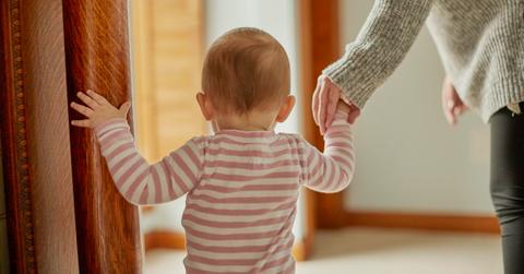 Small child holding a parent's hand.