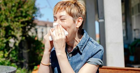 woman sneezing into tissue