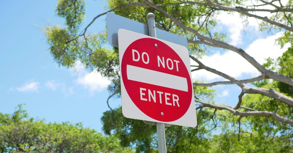 A do not enter sign sits in the middle of a wooded area