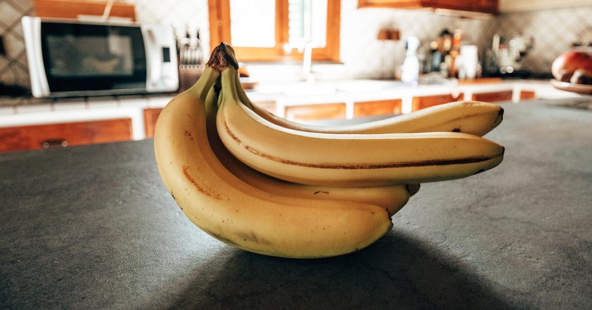 Bunch of bananas sitting on a kitchen counter. 