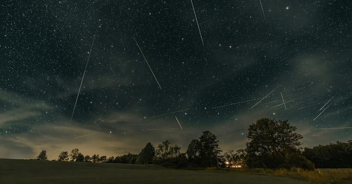 A meteor shower rains down over a house in the wood