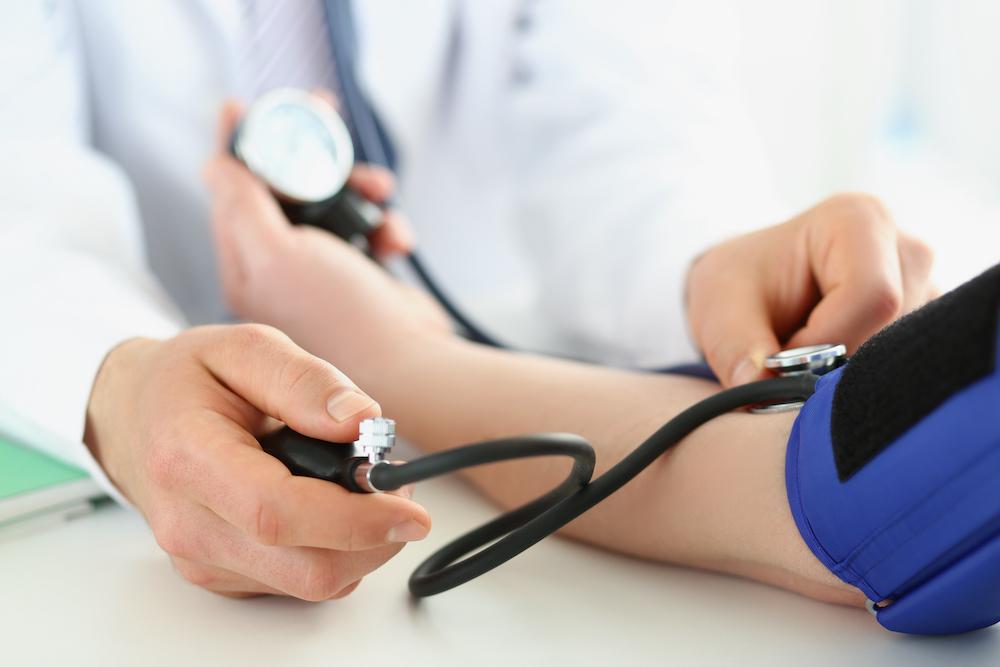 Closeup of doctor checking patient's blood pressure