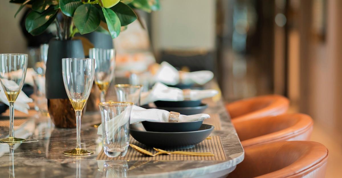 Close up of nice dining chair with wooden table and dish sets