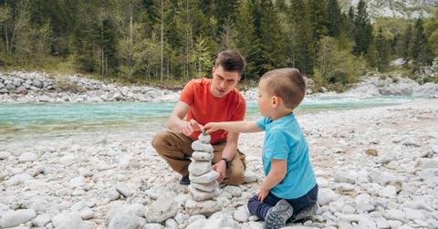 A father-son duo is making a rock stack on a riverbed. (Representative Cover Image Source: Getty Images | Westend61)