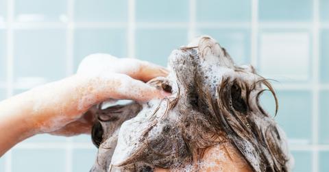 person shampooing hair in shower.