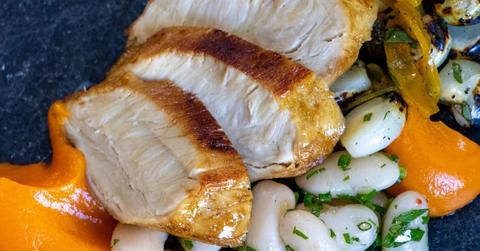 Close-up of lab-grown meat with beans and orange sauce.