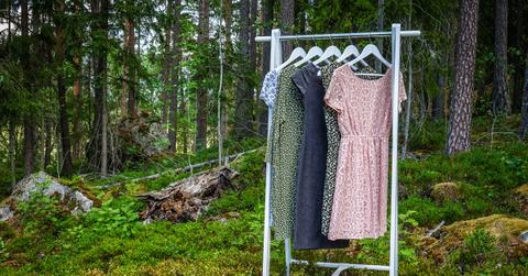 Photo of dresses hanging on a clothing rack in a forest