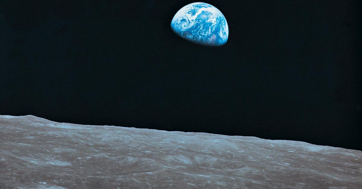 Photo of planet Earth with the moon's surface in the foreground, taken from the moon