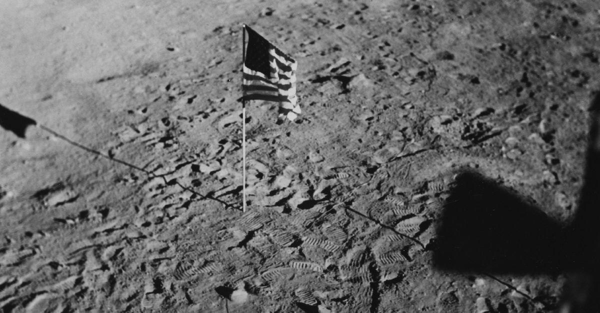 An American flag in the ground on the moon, in black and white.