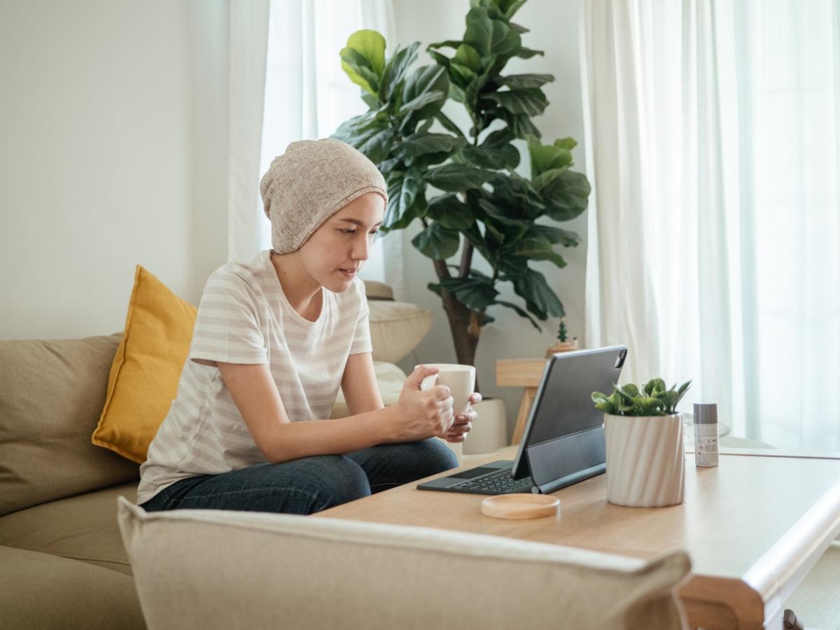 young woman with bald head covered on telehealth call