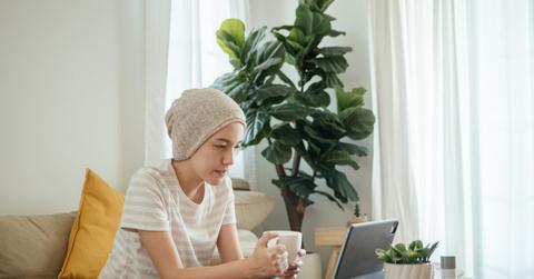young woman with bald head covered on telehealth call