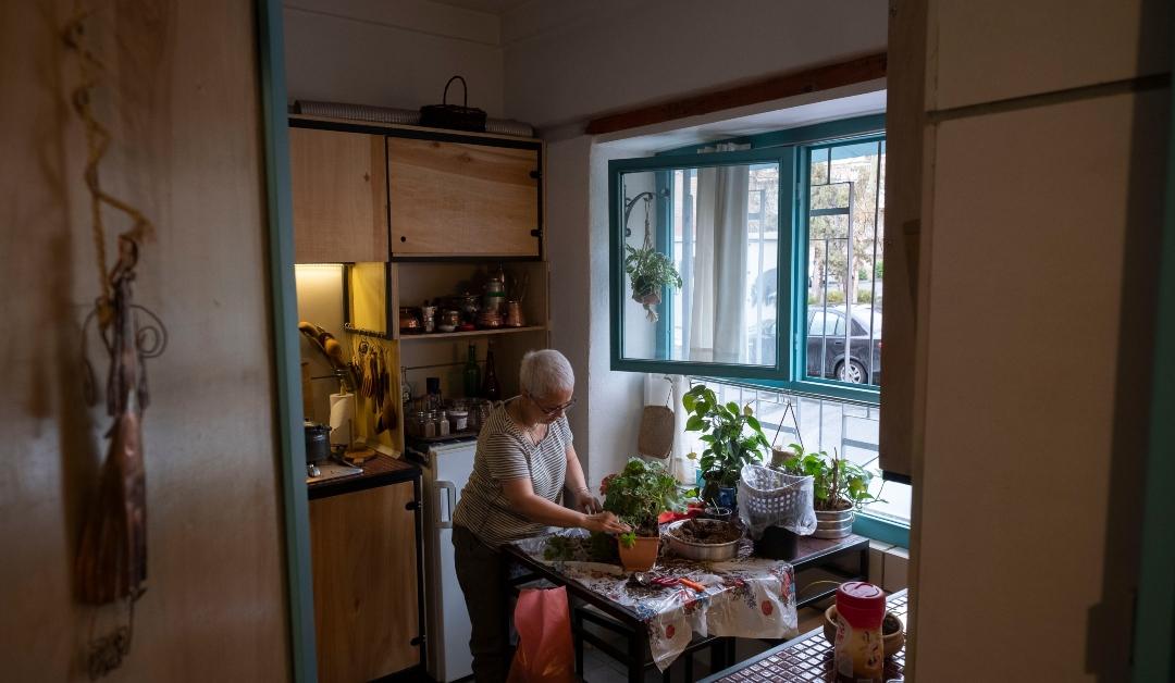 Iranian female painter, Mahta Moini-55, adjusting her plants and flowers in a lighted art studio 