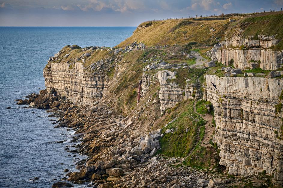 A high-angle view of a cliffside in Dorset, England on a sunny day. 