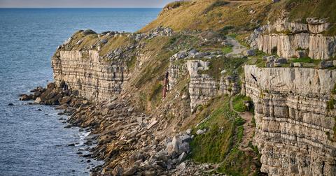 A high-angle view of a cliffside in Dorset, England on a sunny day.