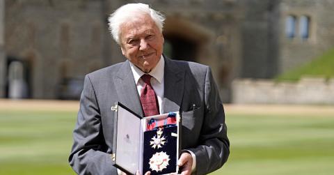 Sir David Attenborough holding his award after being appointed a Knight Grand Cross of the Order of St Michael and St George.