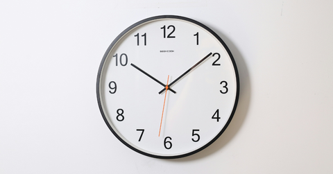 An analogue clock hangs on the wall