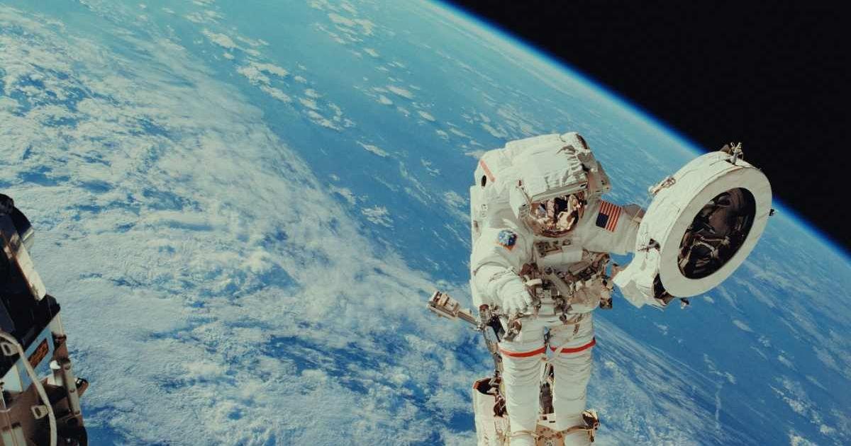 An astronaut doing a spacewalk looks at the Earth. (Representative Cover Image Source: Unsplash | NASA)