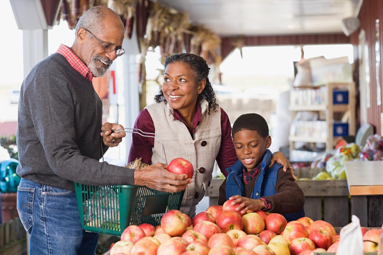 A family picks fresh apples from their local market.