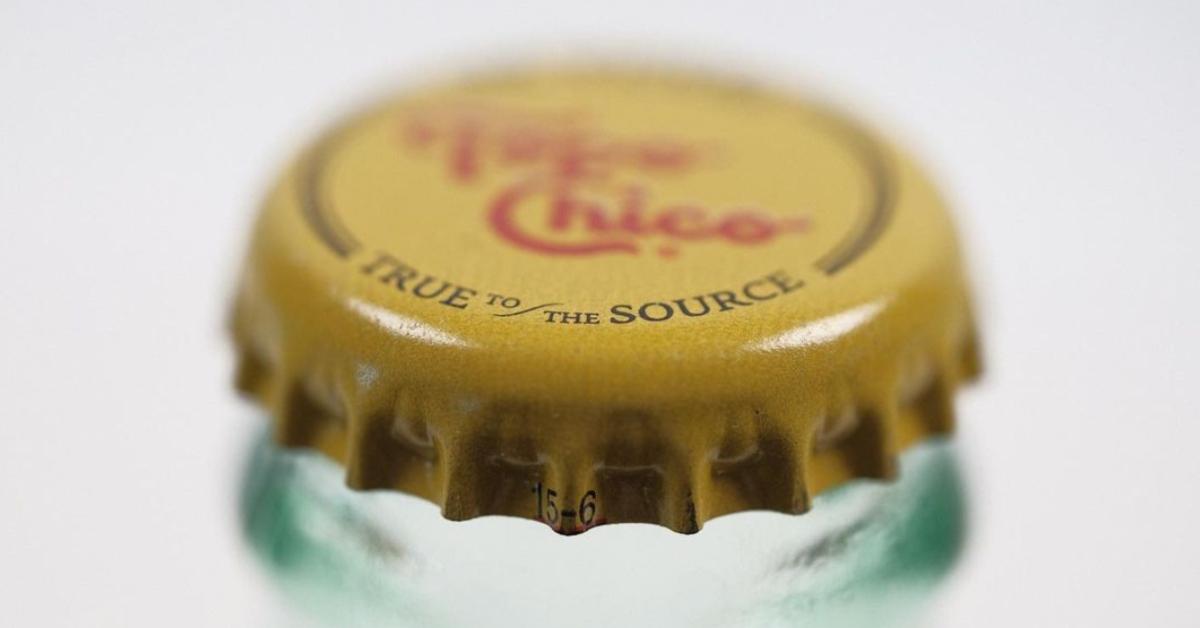 A close up photo of a Topo Chico bottle's yellow cap with the logo "Topo Chico" in red. 