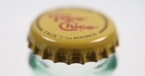 A close up photo of a Topo Chico bottle's yellow cap with the logo "Topo Chico" in red.