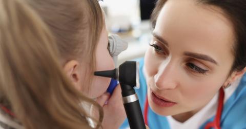 female physician examining girl's ears