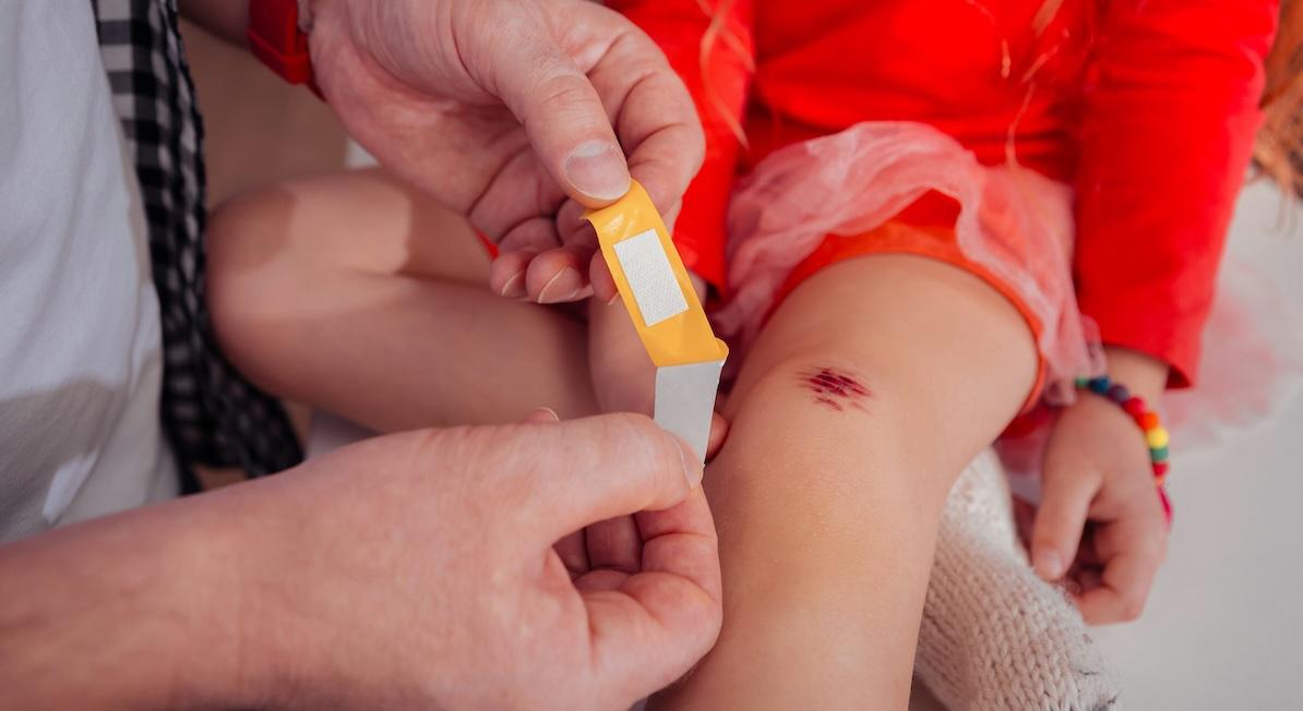 doctor putting bandaid on cut