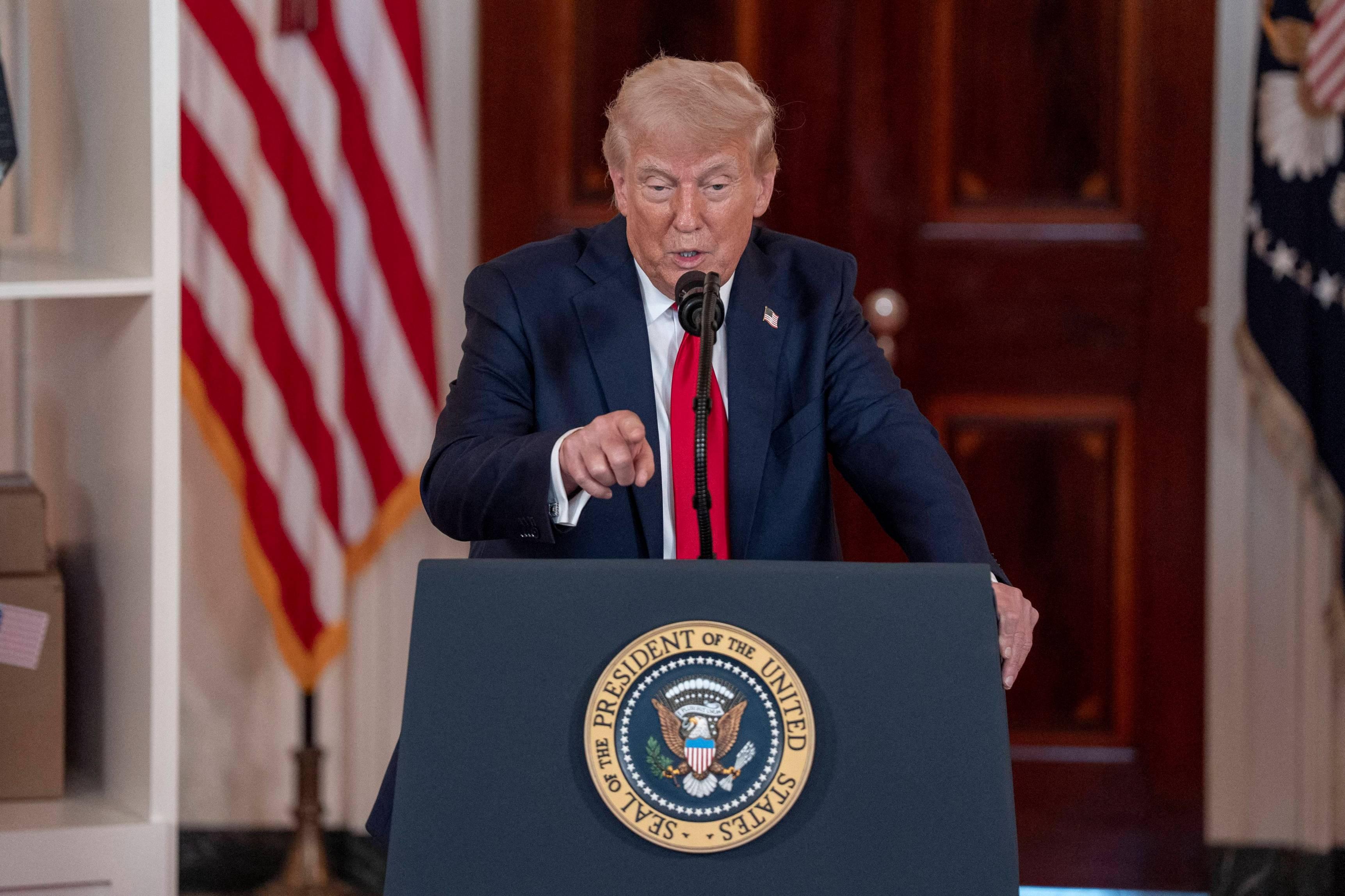 President Donald Trump points at a pool of reporters at at the White House on April 30.