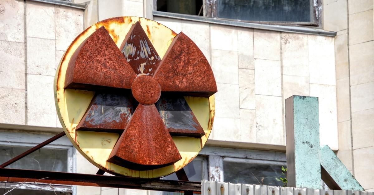 A red and yellow radiation sign hangs above an abandoned building in Chernobyl 