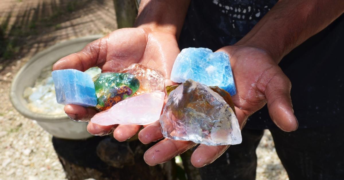 Photo of hands holding various chunks of mined crystals